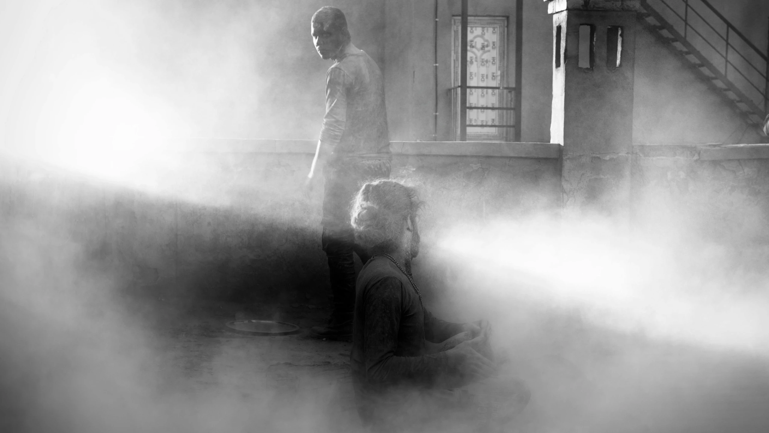 a couple of people that are standing in the fog, a black and white photo, by Adam Marczyński, conceptual art, photorealistic logan movie still, bathing in light, dusty street, exorcist