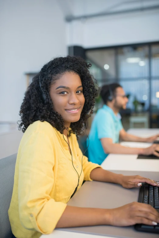 a woman sitting at a desk using a computer, trending on pexels, light skinned african young girl, wearing headset, in rows, avatar image