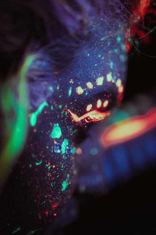 a close up of a person with paint on their face, a microscopic photo, by Adam Marczyński, synchromism, fluorescent spots, vivid tentacles, ✨🕌🌙, with glow on some of its parts