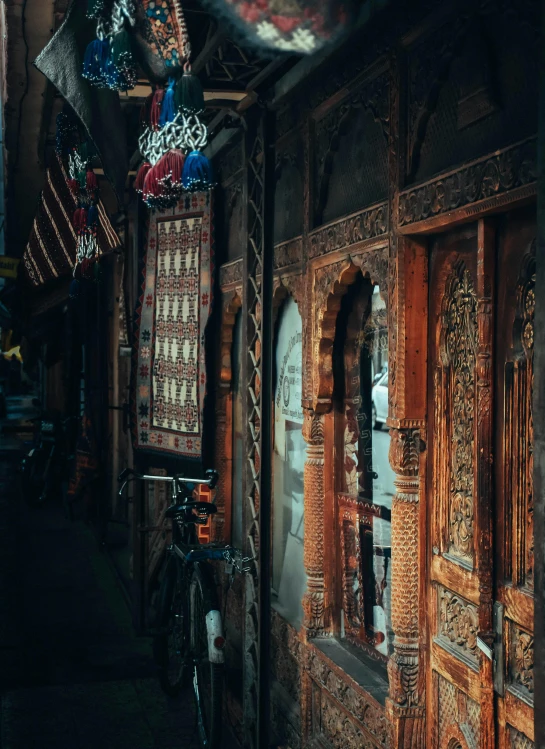 a narrow alley with a bicycle parked next to it, inspired by Osman Hamdi Bey, pexels contest winner, qajar art, intricate carved wood, massive decorated doors, fantastic vendor interior, profile pic