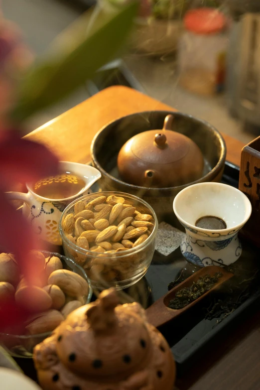 a close up of a tray of food on a table, inspired by Li Di, mingei, nut, cozy setting, golden, spa