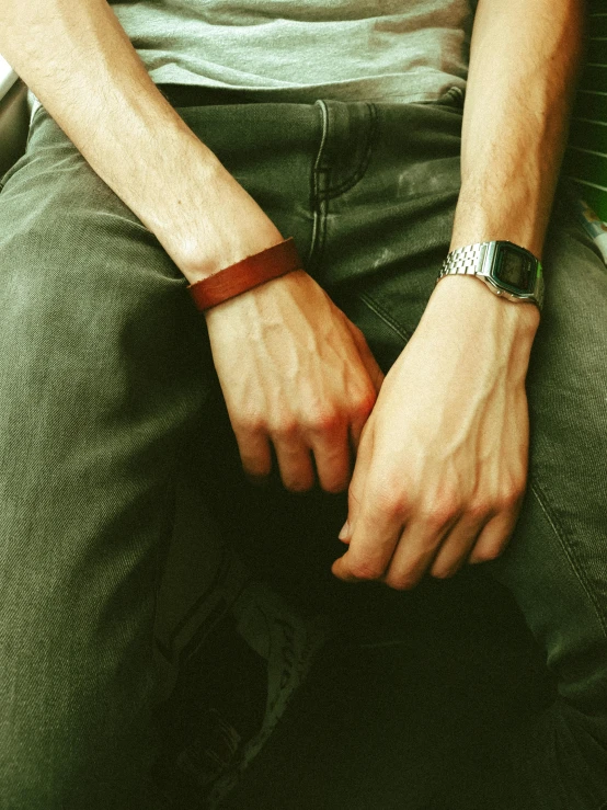 a close up of a person sitting on a bench, leather cuffs around wrists, realistic photo”, ((rust)), square