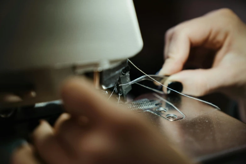 a close up of a person working on a sewing machine, 🦑 design, thumbnail, high quality upload, portrait photo