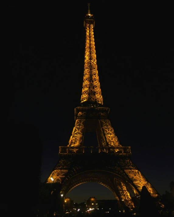 the eiffel tower is lit up at night, an album cover, pexels contest winner, brown, dark photo, 2 0 2 2 photo, historical photo