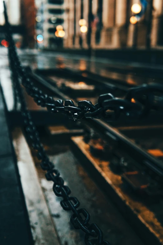 a close up of a chain on a rail, an album cover, inspired by Elsa Bleda, trending on pexels, in a dark dungeon, inside iron and machines, tourist photo, infrastructure