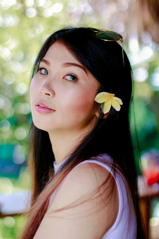 a woman with a flower in her hair, an album cover, inspired by Kim Du-ryang, lovingly looking at camera, miranda cosgrove, profile image, tourist photo