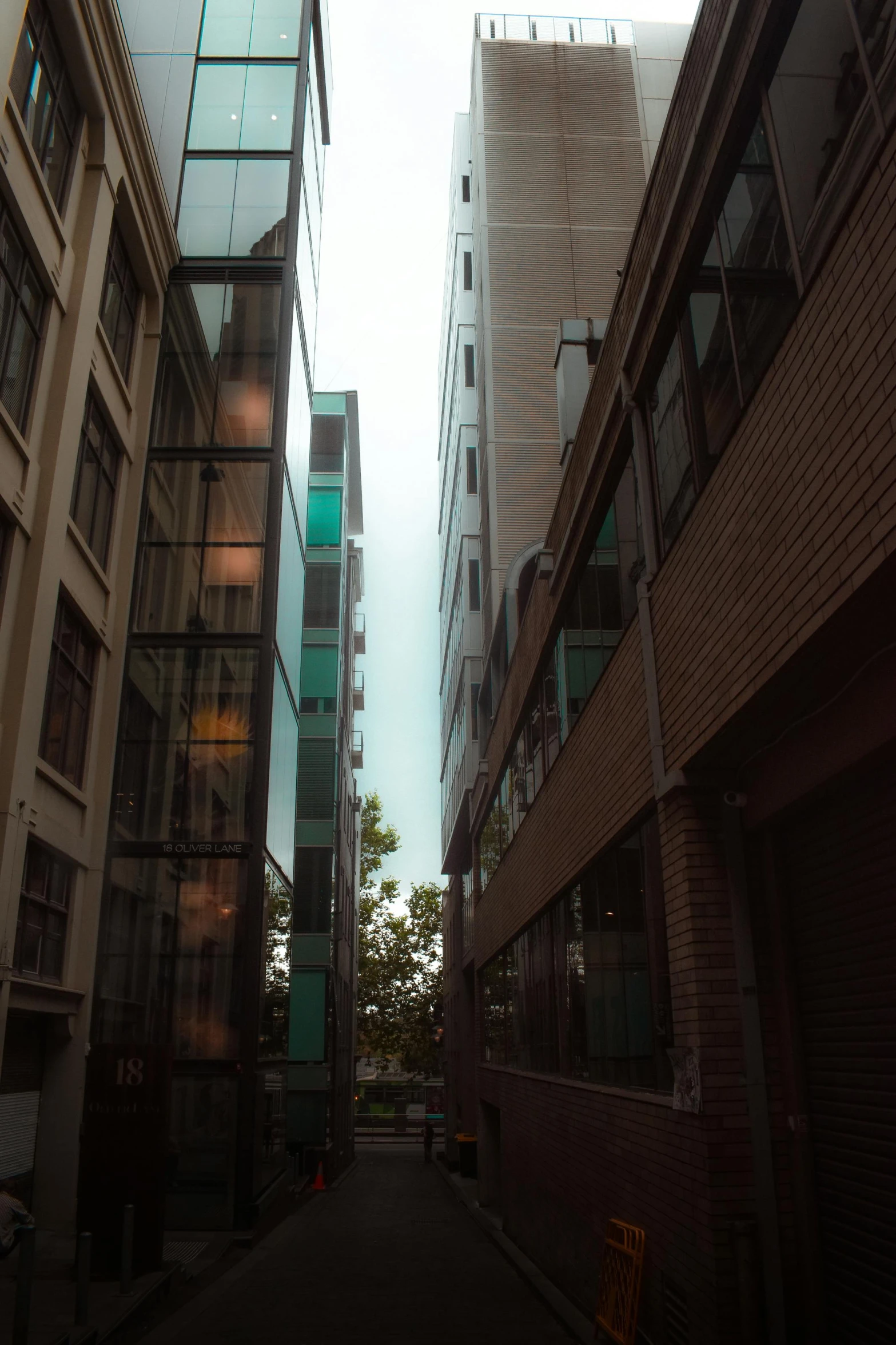 a narrow city street lined with tall buildings, inspired by Thomas Struth, light and space, lots of glass details, dramatic lighting - n 9, north melbourne street, street photo