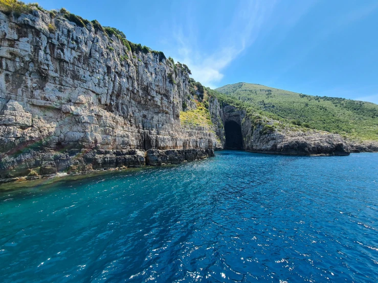 a large body of water next to a cliff, grotto, med bay, profile image, lush surroundings