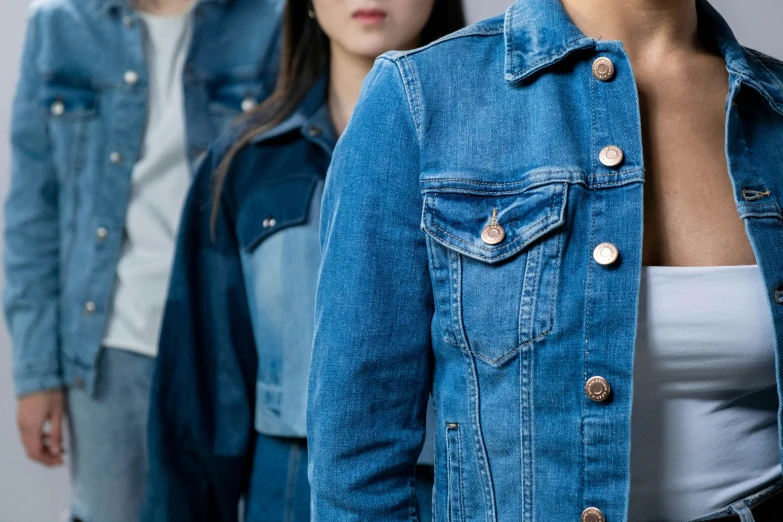 a group of people standing next to each other, trending on pexels, renaissance, denim jacket, three women, zoomed in, medium blue
