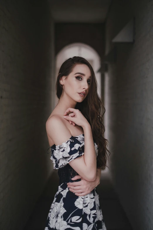 a woman in a dress standing in a hallway, inspired by Elsa Bleda, pexels contest winner, handsome girl, on a gray background, ariana grande photography, curls