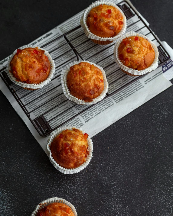 a bunch of muffins sitting on top of a cooling rack, unsplash, dark grey and orange colours, square, melted cheddar, red