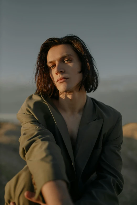 a woman sitting on top of a wooden bench, an album cover, unsplash, bauhaus, handsome man, andrea savchenko, jamie campbell bower, on the desert