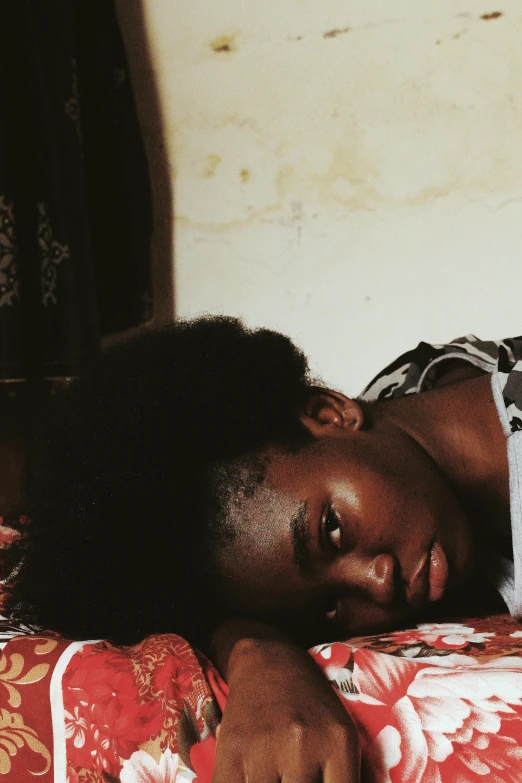 a close up of a person laying on a bed, by Chinwe Chukwuogo-Roy, pexels contest winner, visual art, black young woman, unhappy, mami wata, low fi