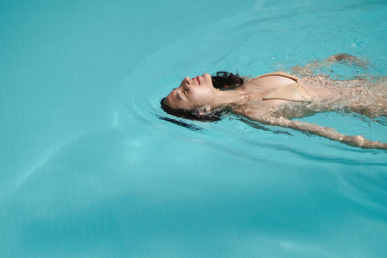 a woman in a bikini swims in a pool, inspired by Elsa Bleda, hyperrealism, hammershøi, blue sky, colour photograph, ignant