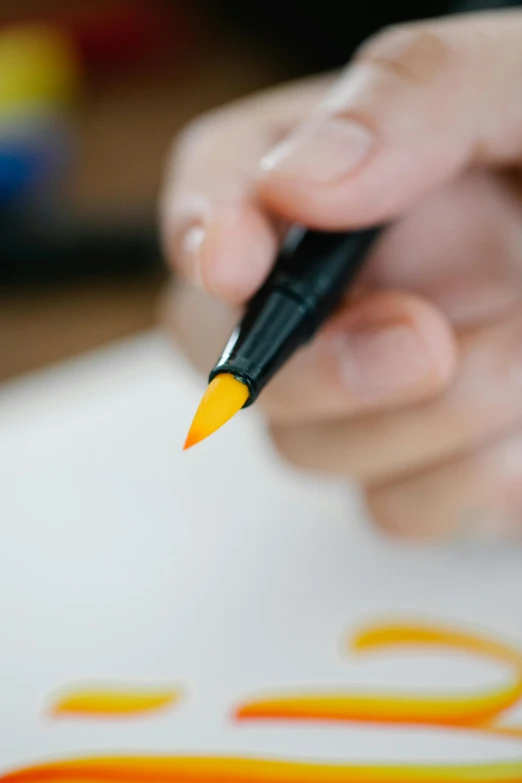 a close up of a person writing on a piece of paper, an airbrush painting, trending on pexels, academic art, yellow orange, copic marker, ultrawide watercolor, yellow and black