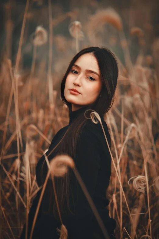 a woman standing in a field of tall grass, a picture, by irakli nadar, pexels contest winner, handsome girl, in fall, asian features, medium format