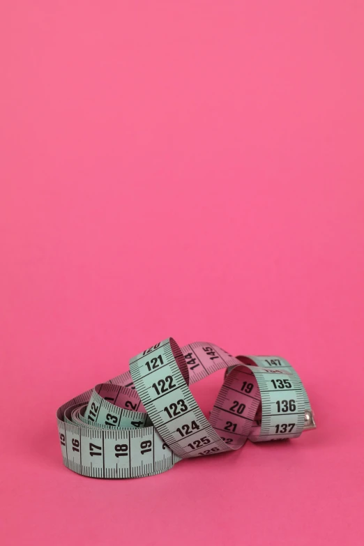 a pair of measuring tape on a pink background, by Emma Andijewska, pexels, prize winning color photo, midriff, | 35mm|, in 2 0 1 2