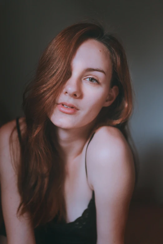 a beautiful young woman sitting on top of a bed, inspired by Elsa Bleda, pexels contest winner, renaissance, brown-red-hair pretty face, she is wearing a black tank top, headshot profile picture, extremely pale