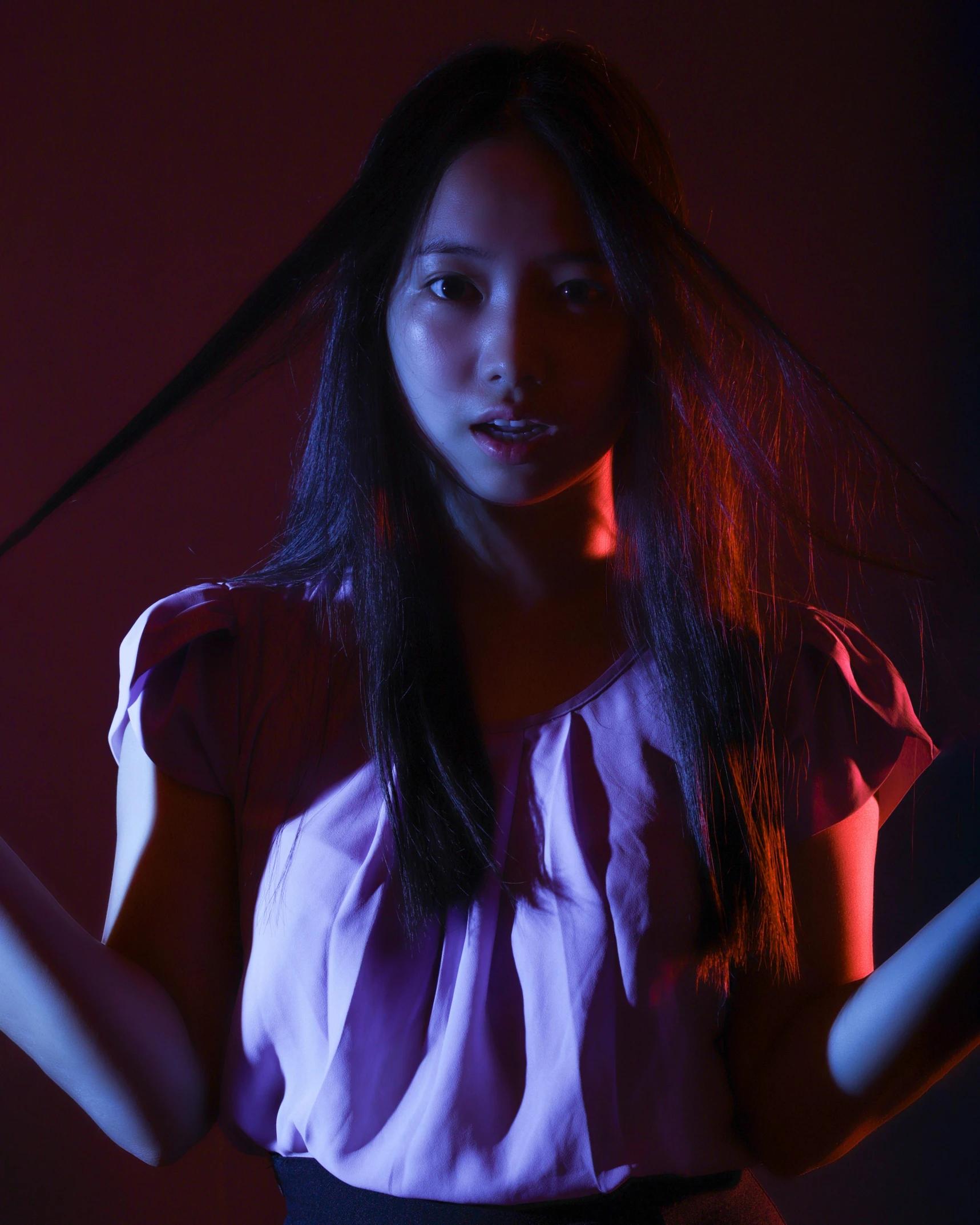 a woman holding a pair of scissors in her hands, an album cover, inspired by Ayako Rokkaku, unsplash, conceptual art, purple light, young asian girl, red light, bisexual lighting