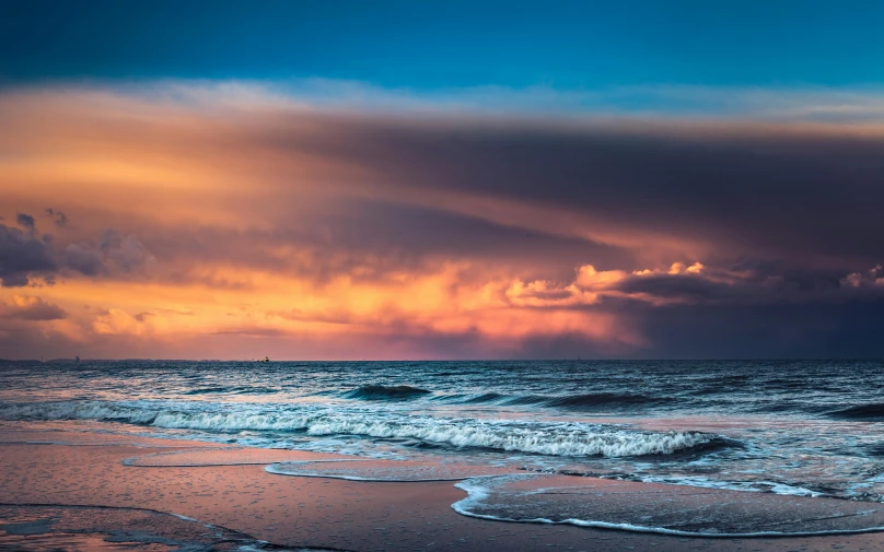 a large body of water next to a beach, by Jesper Knudsen, unsplash contest winner, romanticism, colorful clouds, stormy ocean, thumbnail, blue and orange