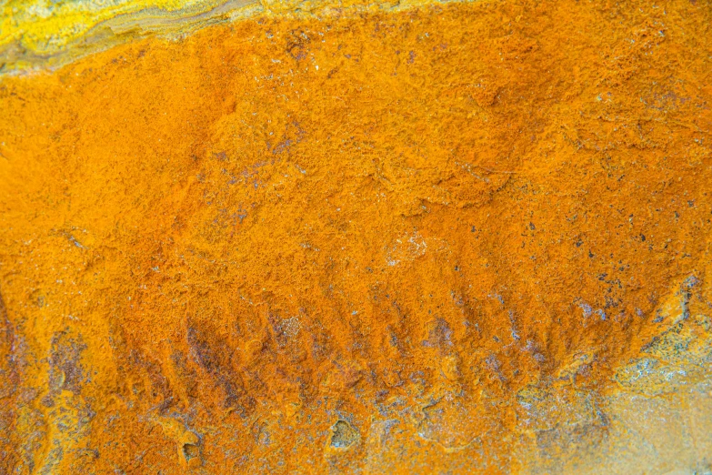 a close up of an orange substance on a rock, inspired by John Steuart Curry, color field, seen from above, iron smelting pits, yellow colours, archival pigment print