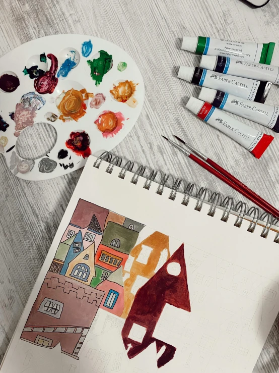 a drawing of a house sitting on top of a table, a child's drawing, inspired by Pablo Picasso, pexels contest winner, process art, gouache and wash paints color, burnt sienna and venetian red, flatlay, ultrawide watercolor