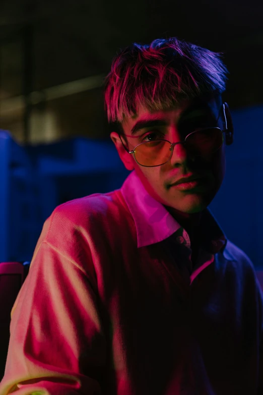 a man wearing glasses and a pink shirt, an album cover, inspired by Liam Wong, pexels contest winner, blonde boy with yellow eyes, lit up in a dark room, justin bieber, asian man