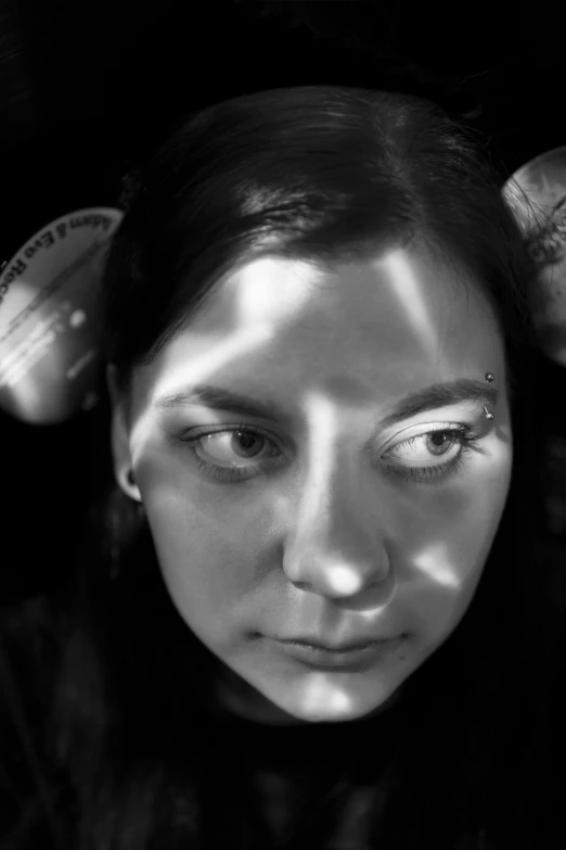 a black and white photo of a woman brushing her hair, inspired by Marina Abramović, reddit, hyperrealism, cassandra cain, two identical symmetrical eyes, horned, metal ears