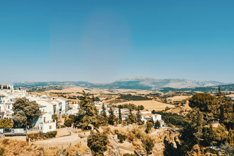 a view of a town from the top of a hill, pexels contest winner, les nabis, jerez, overlooking a valley with trees, white, blue