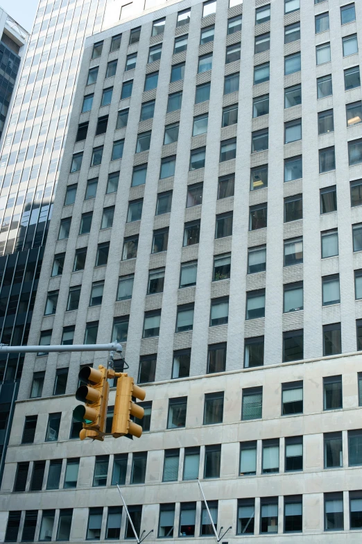 a traffic light sitting in front of a tall building, thumbnail, new york buildings, uncropped, lots of windows