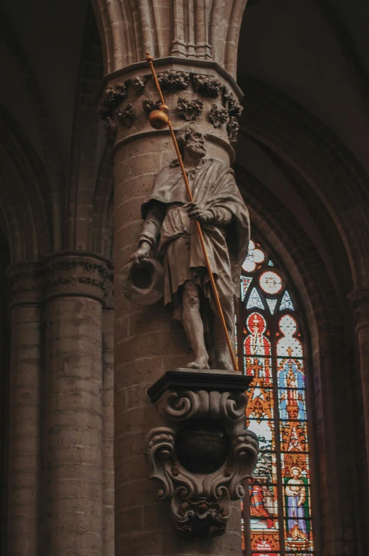 a statue in front of a stained glass window, a statue, by Barthélemy d'Eyck, pexels contest winner, romanesque, long trunk holding a wand, church interior, holding a bagpipe, gray men