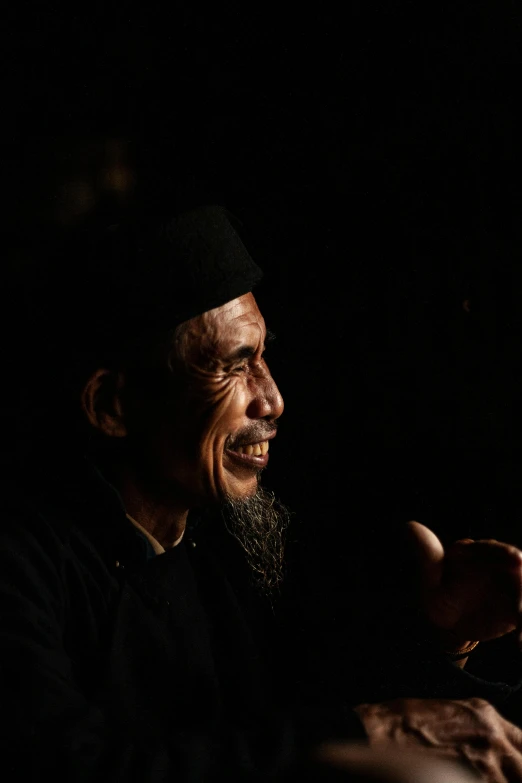 a man with a beard sitting in front of a microphone, a picture, inspired by Xie Huan, pexels contest winner, sumatraism, low-light photograph, religious, jokowi, man in black