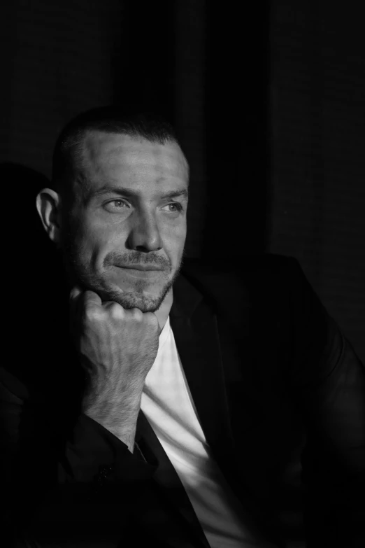 a black and white photo of a man in a suit, a black and white photo, inspired by Carlo Mense, renaissance, triple h, luke evans, portrait of chester bennington, contemplating
