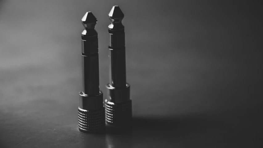 two pens sitting next to each other on a table, a black and white photo, by Adam Rex, steel studs, shogun audio, highly detailed product photo, detailed medium format photo