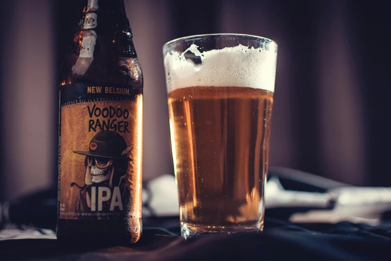 a glass of beer next to a bottle of beer, unsplash, dada, ranger, voodoo, new england ipa, trooper