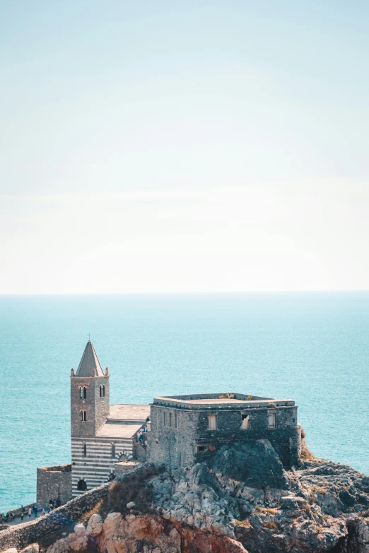 a castle sitting on top of a cliff next to the ocean, churches, italian renaissance architecture, ruined, zoomed out