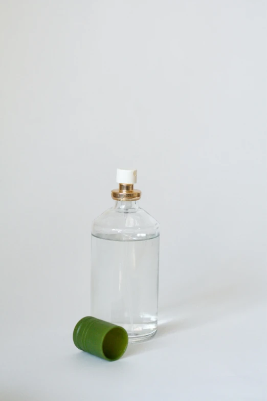 a bottle sitting on top of a white table, by Olivia Peguero, water spray, prop, product, small