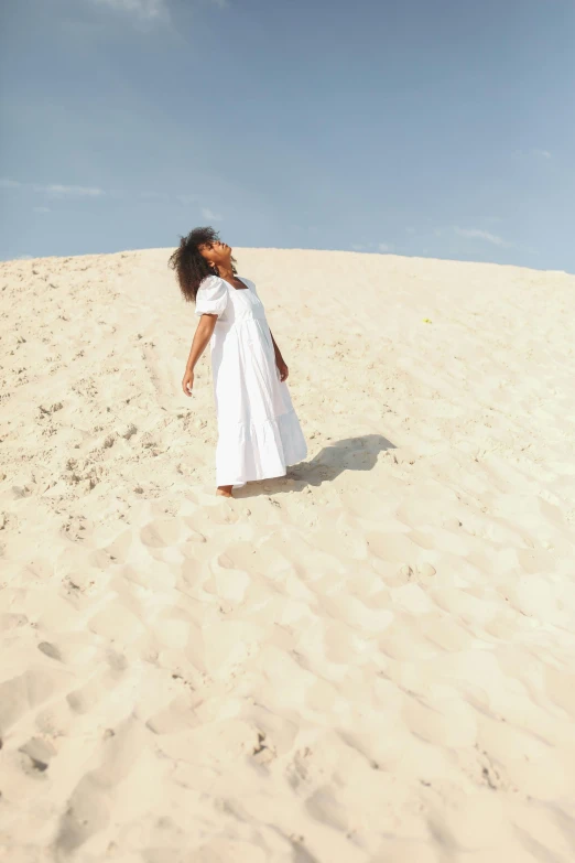 a woman in a white dress standing in the sand, an album cover, by Lily Delissa Joseph, trending on unsplash, arabesque, sza, on dune, actress, snacks