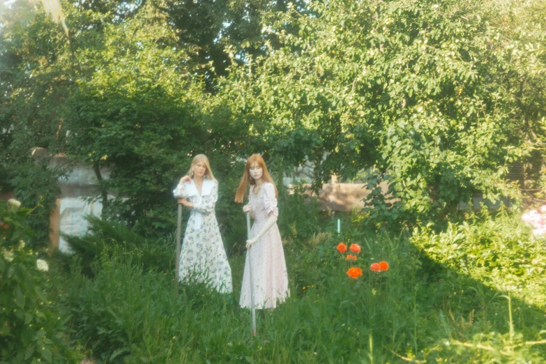 a couple of women standing on top of a lush green field, an album cover, inspired by Konstantin Somov, tumblr, ellie bamber, low quality photo, white, taken on iphone 14 pro