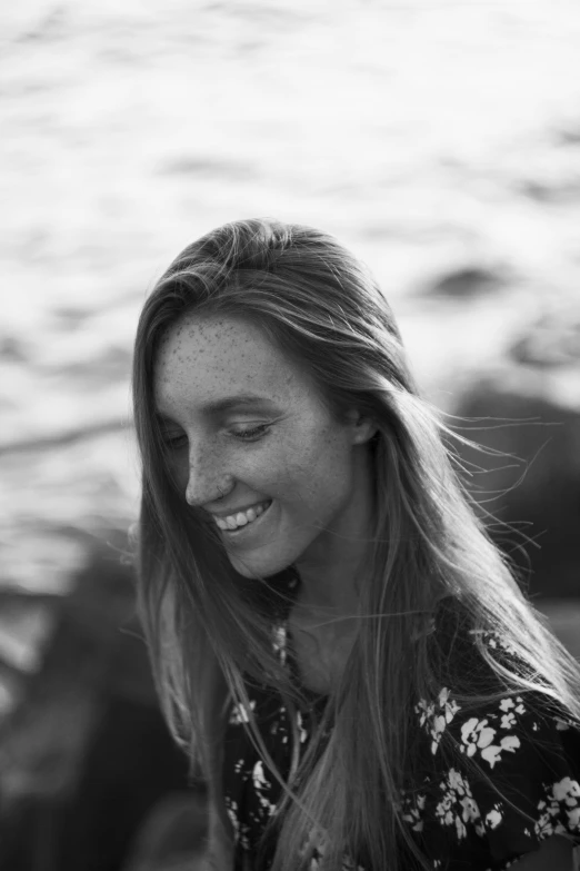 a black and white photo of a woman on the beach, ginger hair with freckles, smiling down from above, hannah yata charlie immer, professional profile picture