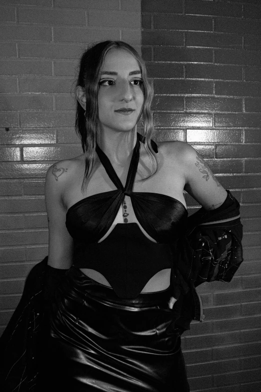 a black and white photo of a woman in a black dress, an album cover, inspired by Taro Yamamoto, reddit, wearing space techwear, wearing leather bikini, ( ( cyberpunk ) ), indoor picture