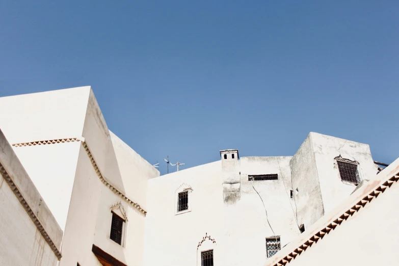 a white building with a blue sky in the background, inspired by Riad Beyrouti, unsplash contest winner, les nabis, background image, poor buildings, conde nast traveler photo, historical photo