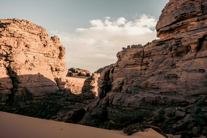 a man riding a surfboard on top of a sandy beach, les nabis, chiseled formations, in a dusty red desert, landscape photo, chasm