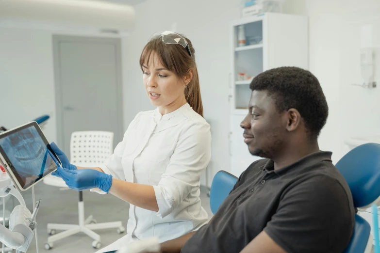 a couple of people that are sitting in a chair, wearing gloves, profile image, dentist, diverse