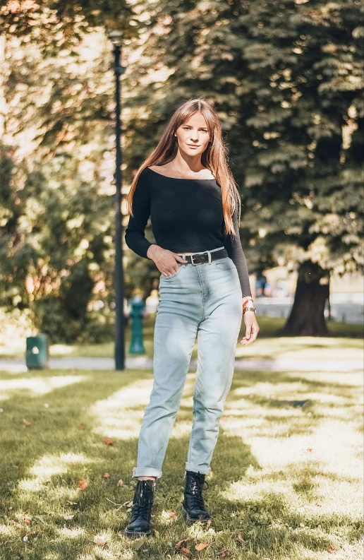 a woman standing on top of a lush green field, tight denim jeans, wearing a black sweater, 5 0 0 px models, 2708519935