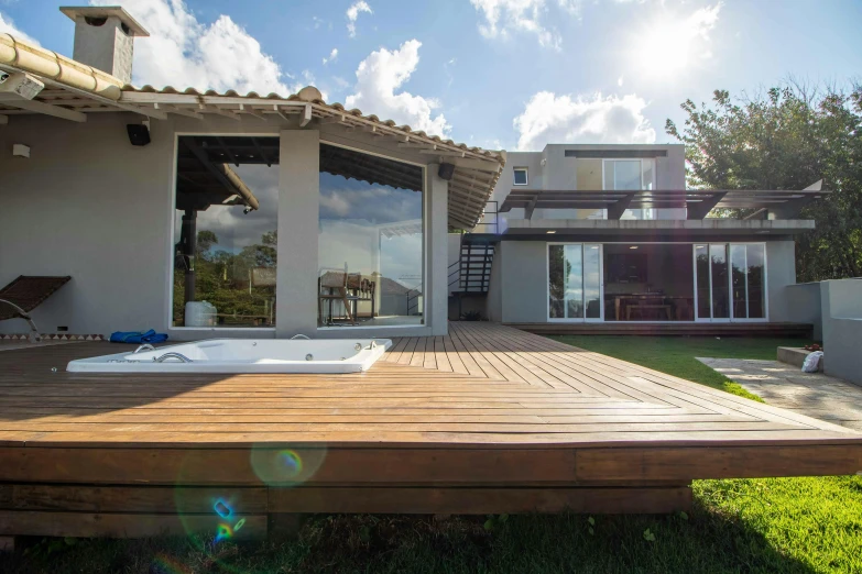 a hot tub sitting on top of a wooden deck, a picture, by Daniel Lieske, unsplash, sao paulo, inter dimensional villa, clear sunny day, avatar image