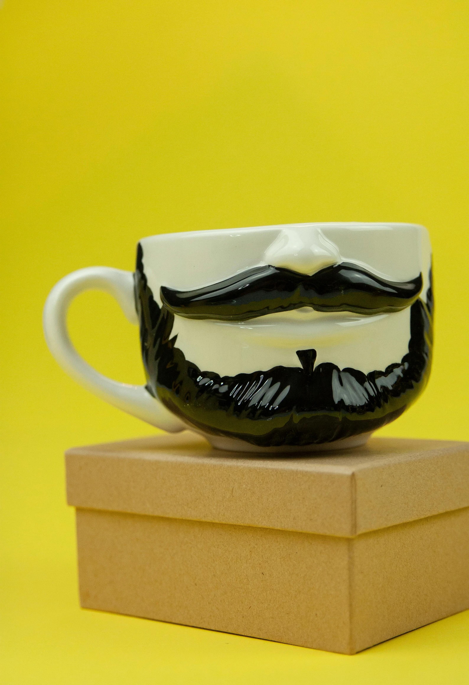 a coffee cup sitting on top of a box, with a full black beard, ceramic looking face, detailed product shot, cheery