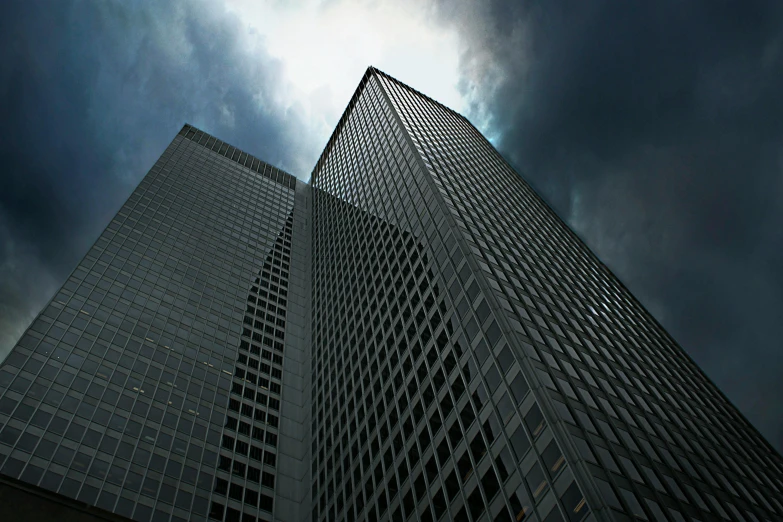 a couple of tall buildings under a cloudy sky, an album cover, pexels contest winner, photorealism, . dramatic angle, corporate, dramatic lighting - n 9, ((monolith))