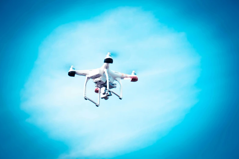 a white drone flying through a blue sky, unsplash, figuration libre, square, electronics, a brightly coloured, very grainy