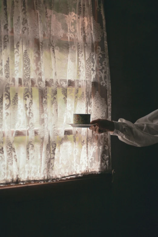 a person holding a tray in front of a window, pexels contest winner, australian tonalism, curtains, coffee cup, rinko kawauchi, historical photo